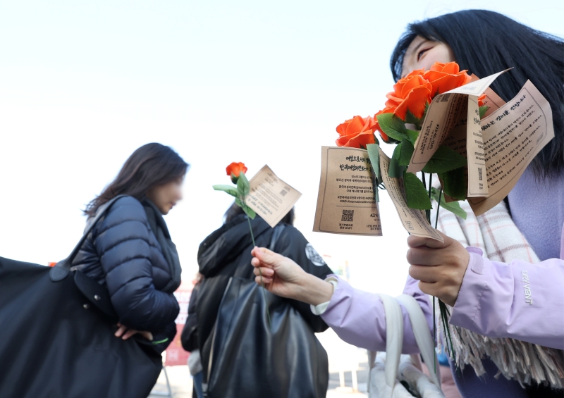 Para conmemorar el Día Internacional de la Mujer, un miembro de la organización activista sin ánimo de lucro Korea Women's Hot Line entrega el 8 de marzo rosas a estudiantes de la Universidad Femenina de Ewha, en el distrito Seodaemun-gu de Seúl. Este día, el grupo distribuyó rosas a unas 5.000 mujeres de Seúl.