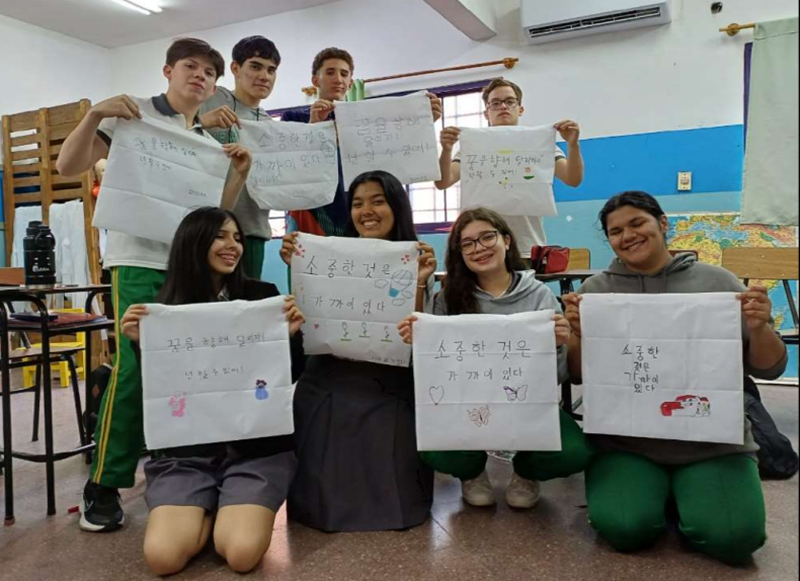 Estudiantes paraguayos se toman una foto conmemorativa después de escribir frases en coreano durante la clase de caligrafía. | Ministerio de Educación de Corea