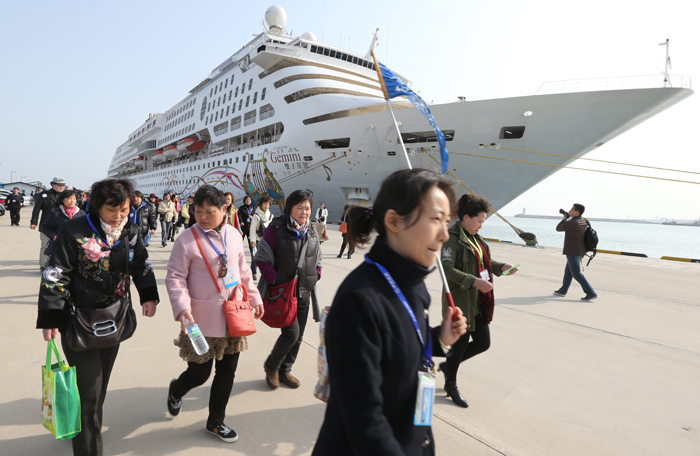 Tourists from Super Star Gemini, a large cruise ship run by the Hong Kong-based Star Cruises, depart from the ship to look around Jeju Island on April 9 (photo: Yonhap News).