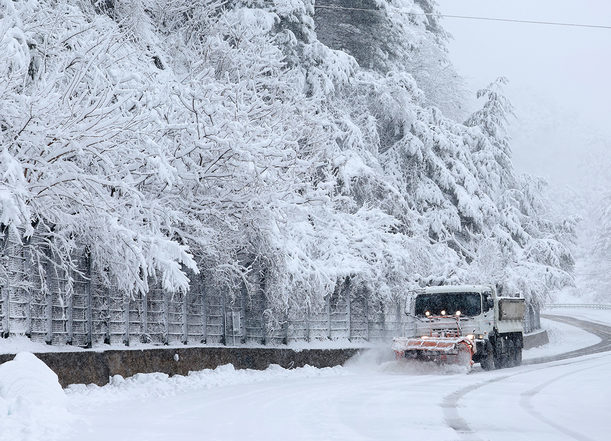 En la mañana del 26 de marzo, cuando más de 30 centímetros de nieve cayeron en las regiones montañosas de la provincia de Gangwon-do, un camión esparcidor de sal eléctrico quita la nieve que se acumuló en la antigua carretera de Guryongryeong, en el condado de Yangyang-gun.