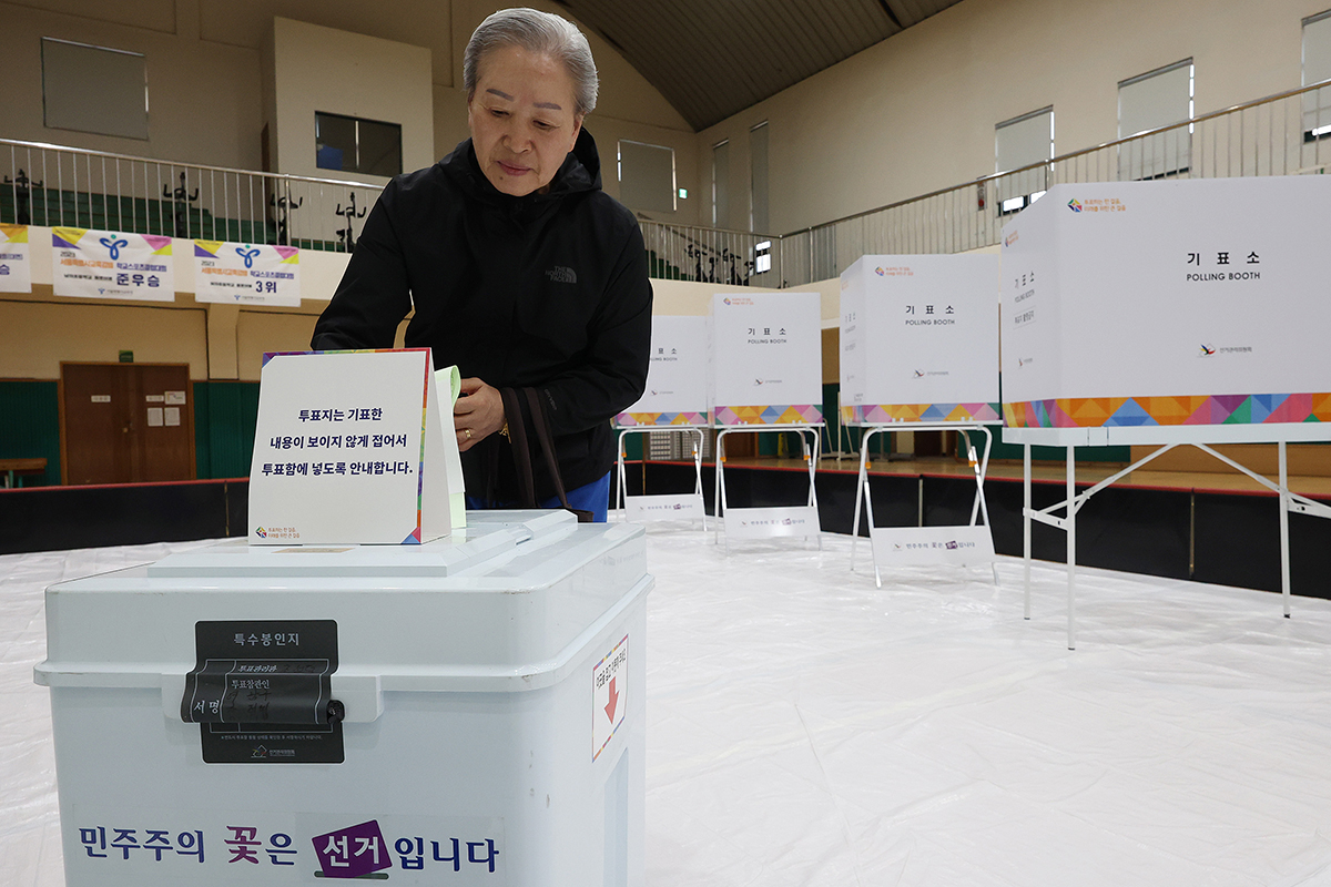 En la mañana del 10 de abril, una votante deposita su voto para las 22ª elecciones generales en la Escuela Primaria Samkwang, tercer colegio electoral del barrio de Huam-dong, en el distrito de Yongsan-gu de Seúl.