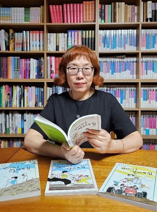 La escritora surcoreana Lee Geum-yi abre una de sus obras en el estudio de su casa, ubicada en el distrito de Jung-gu, en Seúl.