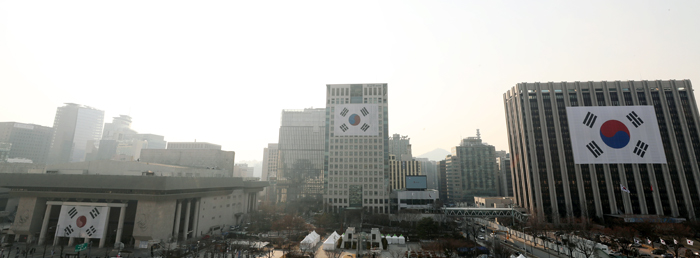 Banderas gigantes coreanas que datan de principios de 1900, el 27 de febrero, se encuentran izadas en edificios frente a la plaza Gwanghwamun dos días antes del centenario del Movimiento por la Independencia del Primero de Marzo. En la foto se muestran las banderas Taegeuki de 1923 (izda.), 1941 (centro) y el día de hoy.