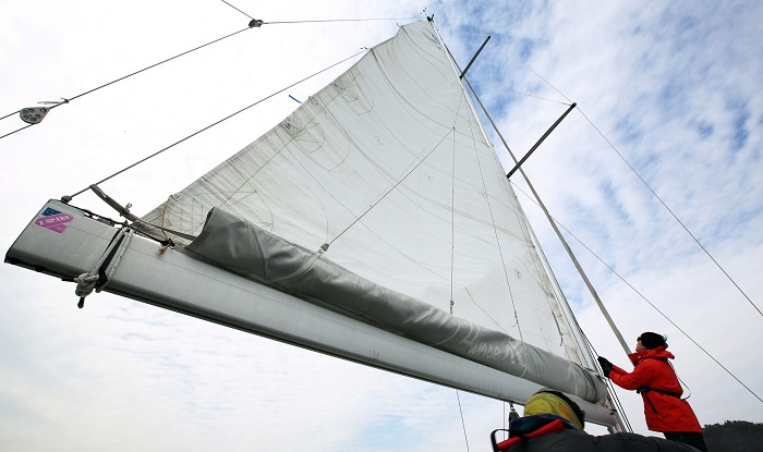 바람의 힘을 이용해 크루즈요트의 닻을 조정하는 요트 운전자. 가격이 생각보다 저렴해 요트 체험을 하고자 하는 방문객이 점점 많아지고 있다. 