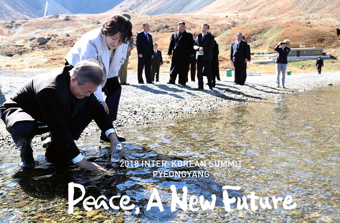 El presidente Moon Jae-in llena la botella con el agua del lago del cráter Cheonji en su viaje al monte Baekdu con el líder norcoreano Kim Jong Un, el 20 de septiembre.
