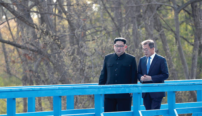 El Presidente Moon Jae-in y el Líder Kim Jong-un caminando juntos por un puente en la villa fronteriza de Panmunjeom