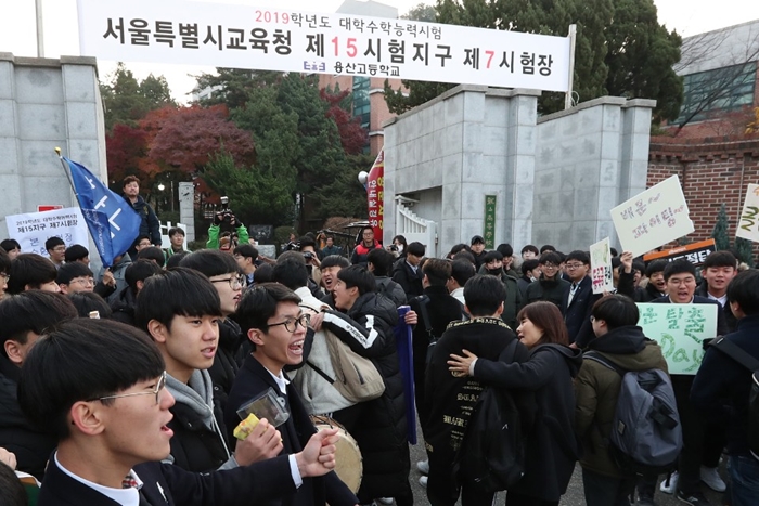 El 15 de noviembre, día de la prueba de ingreso en la universidad, los examinados entran a la sala de examen con el apoyo de estudiantes de primer año y maestros, en la Escuela Secundaria de Yongsan en el distrito de Yongsan-gu, Seúl. | Jeon So-hyang de Ministerio de Cultura, Deporte y Turismo