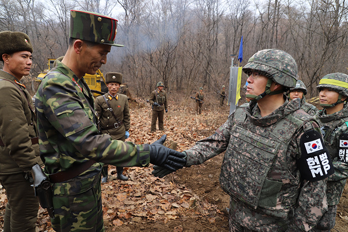 Los soldados de Corea del Sur y del Norte estrechan la mano antes de trabajar en el proyecto de conexión de la carretera por la Línea de Demarcación Militar en Cheorwon, provincia de Gangwon-do, en noviembre de 2018. | Ministerio de Defensa Nacional
