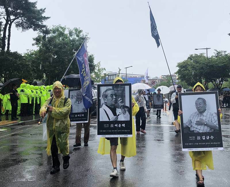 A pesar de la lluvia torrencial en la tarde del 15 de agosto, más personas se reúnen en la marcha en el centro de Seúl. Alrededor de 2.000 se congregaron en la Plaza de Seúl, con algunas fotos de víctimas de trabajos forzados del colonialismo japonés, y exigieron una disculpa sincera del Gobierno de Japón. | Kim Minji