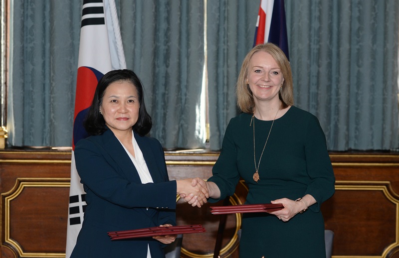 La ministra de Comercio, Industria y Energía de Corea del Sur, Yoo Myung-hee se da la mano con su homóloga del Reino Unido, Elizabeth Truss, en la ceremonia de firma del tratado de libre comercio (TLC), celebrada el 22 de agosto (hora local) en Londres.