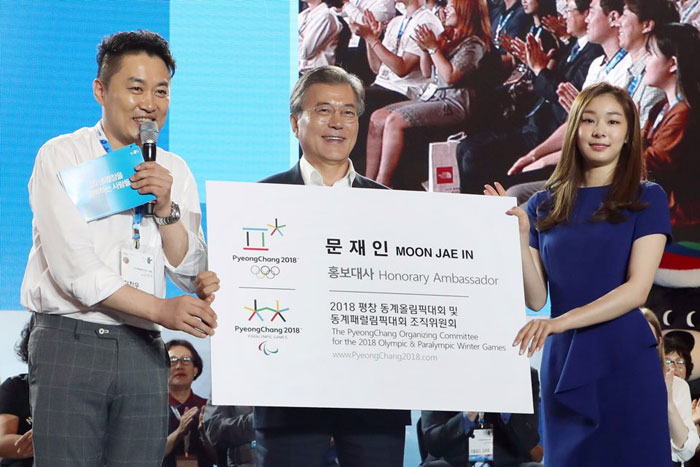 문재인 대통령(가운데)이 24일 ‘2018 평창 동계올림픽’ 개막 200일 앞두고 강원도 평창군 알펜시아 리조트에서 열린 '2018 평창을 준비하는 사람들' 행사에서 홍보대사 김연아와 정찬우로부터 ‘2018 평창동계올림픽∙패럴림픽’ 홍보대사 명함을 전달 받고 있다.