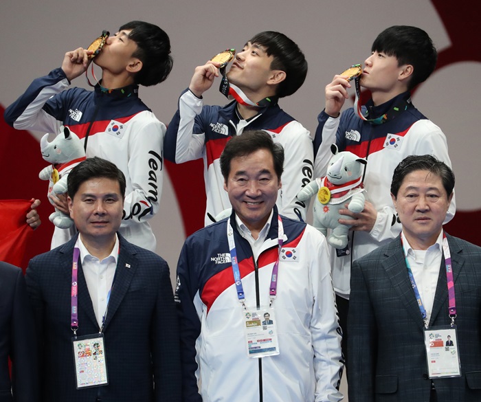 남자 단체전에서 금메달을 획득한 한영훈, 김선호, 강완진이 19일 인도네시아 자카르타 컨벤션센터에서 열린 2018 자카르타-팔렘방 아시안게임 태권도 품새 시상식에서 이낙연 총리와 기념촬영을 하고 있다. 연합뉴스