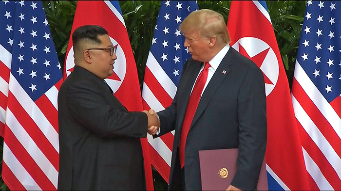 El líder norcoreano Kim Jong Un (izda.) y el presidente estadounidense Donald Trump se dan la mano el 12 de junio de 2018 en el Hotel Capella en la isla Sentosa, Singapur, tras firmar la declaración conjunta. | Yonhap News