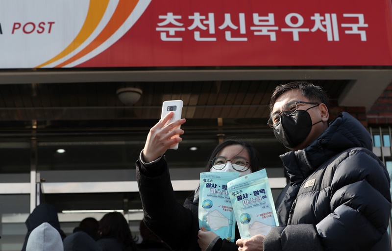 강원 춘천시 신북읍 우체국에서 2일 오전 한국 정부가 공급하는 보건용 마스크를 산 시민들이 스마트폰으로 인증샷을 남기고 있다. 연합뉴스