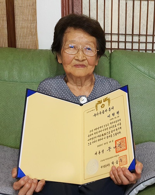 Lee Hyun-won fue nombrada enfermera oficial en 1953 y participó en la Guerra de Corea como teniente de reserva después de ser miembro de la primera generación de graduadas de la Academia de Enfermería de las Fuerzas Armadas de Corea. En la foto tomada el 16 de junio en su casa en Cheongju, provincia de Chungcheongbuk-do, Lee muestra un certificado de mérito nacional que recibió del gobierno. | Lee Kyoung Mi 
