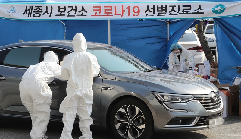 El personal médico recolecta muestras en una clínica de pruebas de autoservicio establecida en un centro de salud pública en la ciudad de Sejong-si en febrero del año pasado.