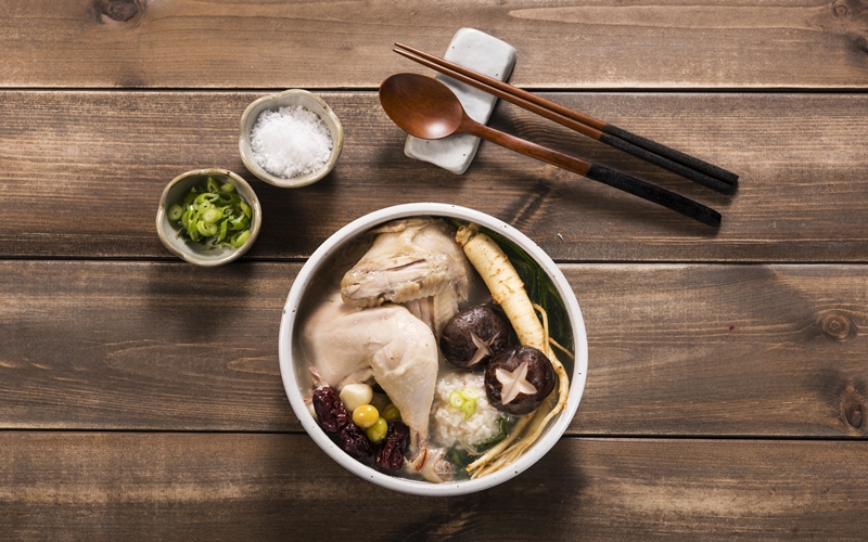 En el artículo la reportera honoraria Nour Gamal menciona que los coreanos comen samgyetang, una sopa caliente de pollo, para soportar el calor del verano. | iClickart