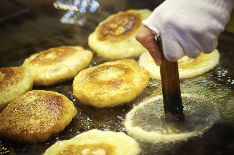 El hotteok es un panqueque dulce con masa de arroz glutinoso relleno de azúcar morena y aplastado sobre una placa de hierro engrasada.