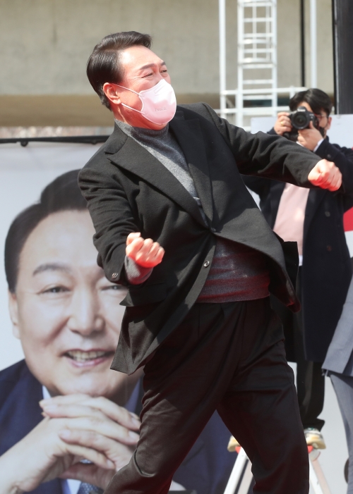 Yoon Suk Yeol, el vigésimo presidente electo, realiza su característico gesto en un sitio de campaña frente al arroyo Oncheoncheon en el distrito de Yeonje-gu, en Busan, la tarde del 8 de marzo.