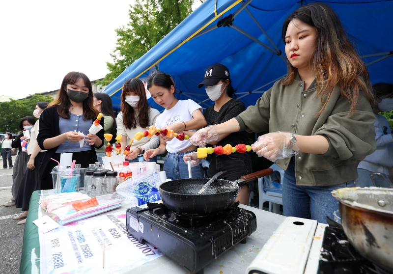 14일 대동제가 열린 서울 서대문구 이화여자대학교에서 융합보건학과 학생들이 탕후루(과일에 설탕, 물엿 등으로 만든 시럽을 바른 뒤 굳혀 먹는 중국 음식)를 만들고 있다.