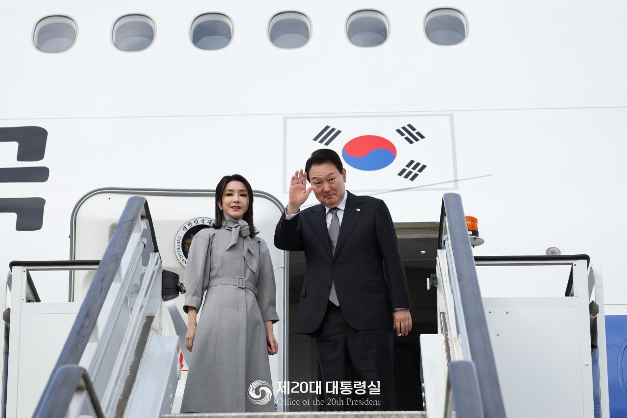 El presidente Yoon Suk Yeol y la primera dama Kim Keon Hee saludan a la multitud el 19 de septiembre antes de abordar el avión presidencial Code One en el Aeropuerto de Stansted en Londres con destino a Nueva York.
