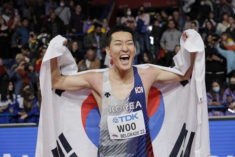Woo Sang-hyeok celebra con la bandera de Corea del Sur, Taegeukgi, después de ganar la medalla de oro en la final de salto de altura masculino del Campeonato Mundial de Atletismo en Pista Cubierta de 2022 celebrado en el Stark Arena en Belgrado, Serbia, el 20 de marzo (hora de Corea). | Agencia de Noticias Yonhap 