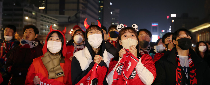 Los de fanáticos del fútbol, reunidos el 24 de noviembre en la plaza Gwanghwamun en Seúl para ver el primer partido de la fase de grupos de Corea en la Copa Mundial de Catar, se sorprenden después de que el jugador uruguayo Diego Godin falla por poco un gol al golpear el poste izquierdo.