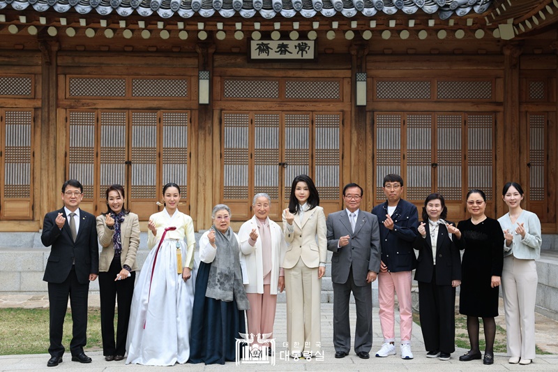 El 4 de abril, la primera dama Kim Keon Hee (sexta desde la izda.) y los herederos de la interpretación y las artes tradicionales que son titulares de algunos bienes culturales intangibles nacionales, posan para tomarse una foto conmemorativa en frente del salón Sangchunjae, en la antigua casa presidencial Cheong Wa Dae. | Oficina presidencial