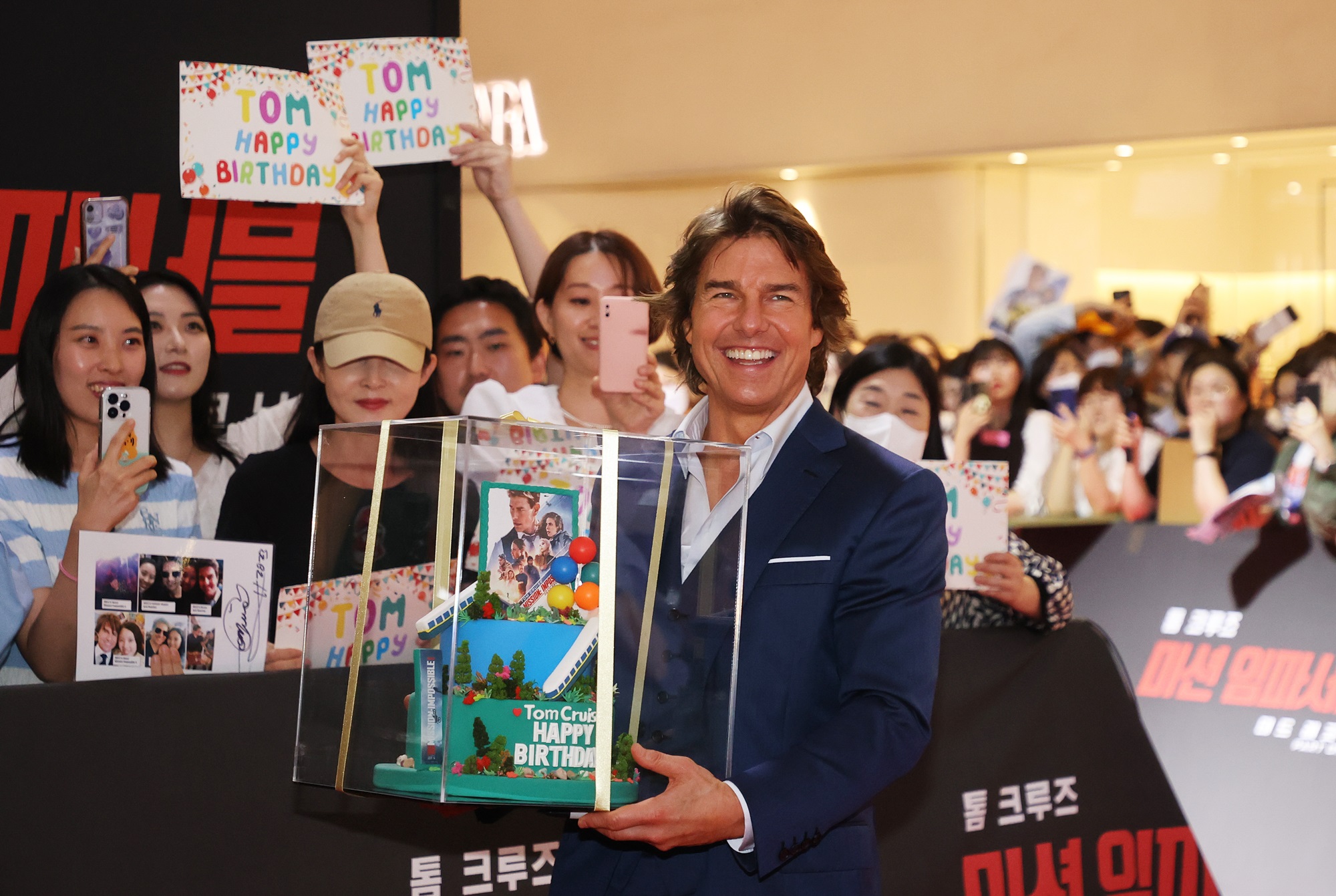 El actor Tom Cruise está recibiendo un pastel de cumpleaños que le regalaron sus fans coreanos en la alfombra roja de la película 'Misión Imposible: Sentencia Mortal Parte Uno', celebrada en el centro comercial Lotte World Tower, en el distrito de Songpa-gu, Seúl. | Agencia de Noticias Yonhap