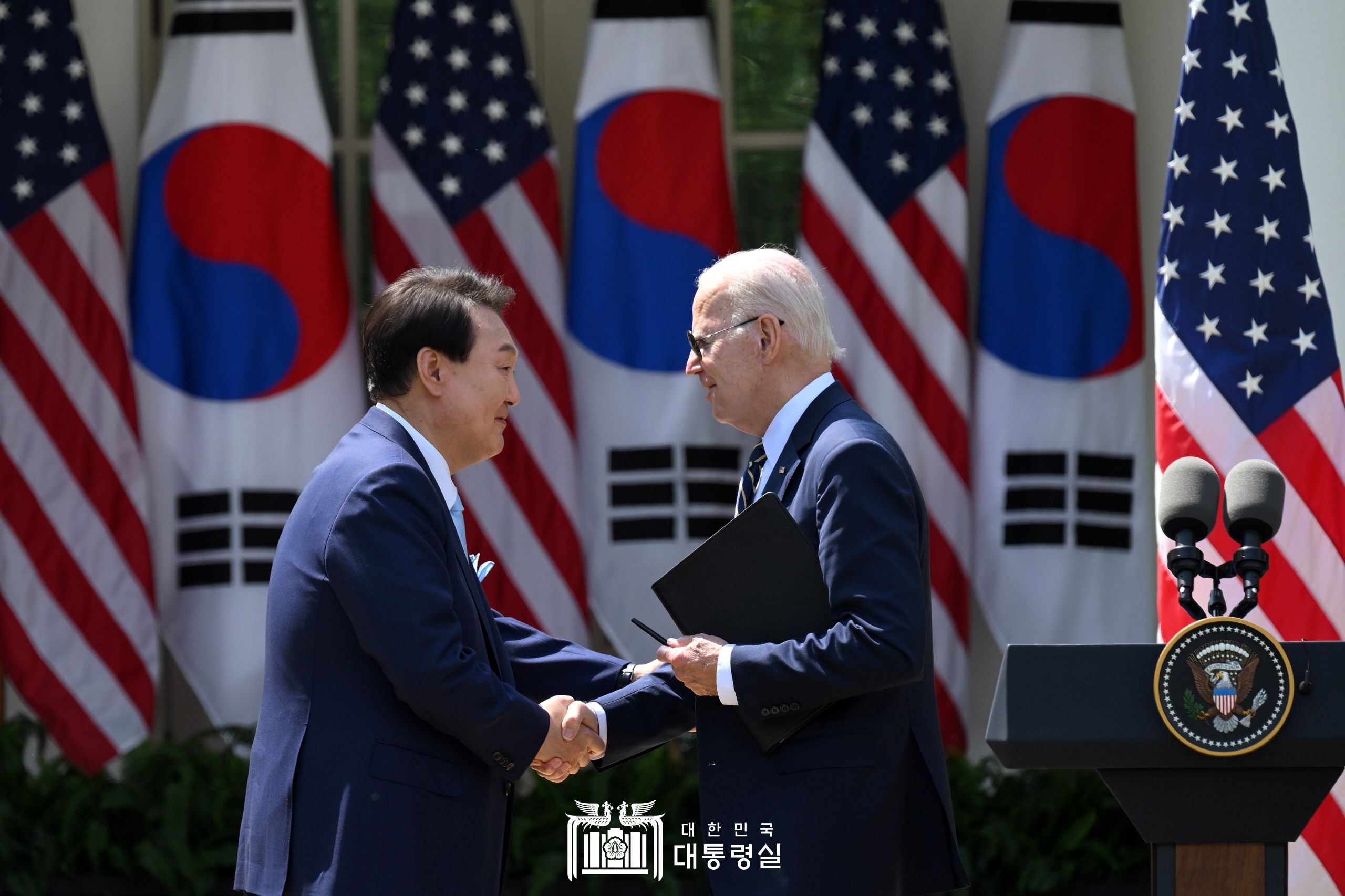 El presidente Yoon Suk Yeol (izda.) y el presidente estadounidense Joe Biden se dan la mano el 26 de abril (hora local) en una rueda de prensa conjunta en la Casa Blanca en Washington, durante la visita de Estado de Yoon a EE. UU. | Oficina presidencial