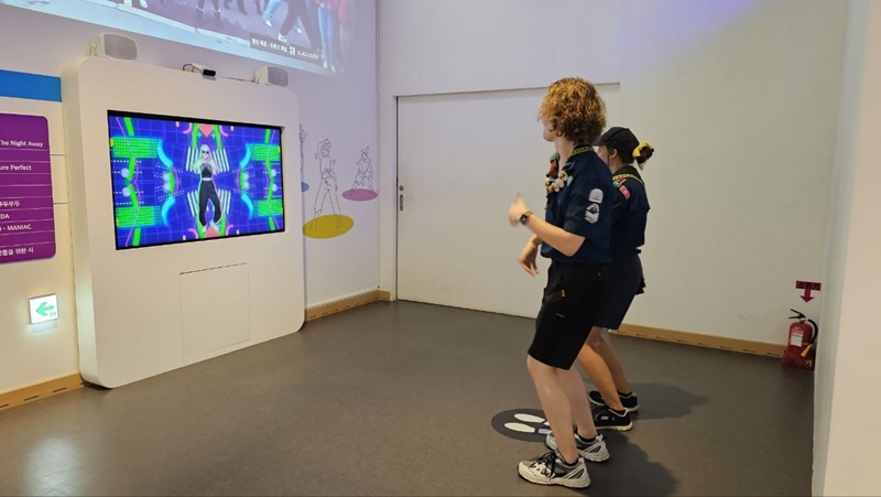  Durante uno de los programas turísticos realizado antes de la inauguración 25° Jamboree Scout Mundial, dos scouts bailan mientras observan la exhibición especial de hallyu presentada en el Museo de Historia de Corea.