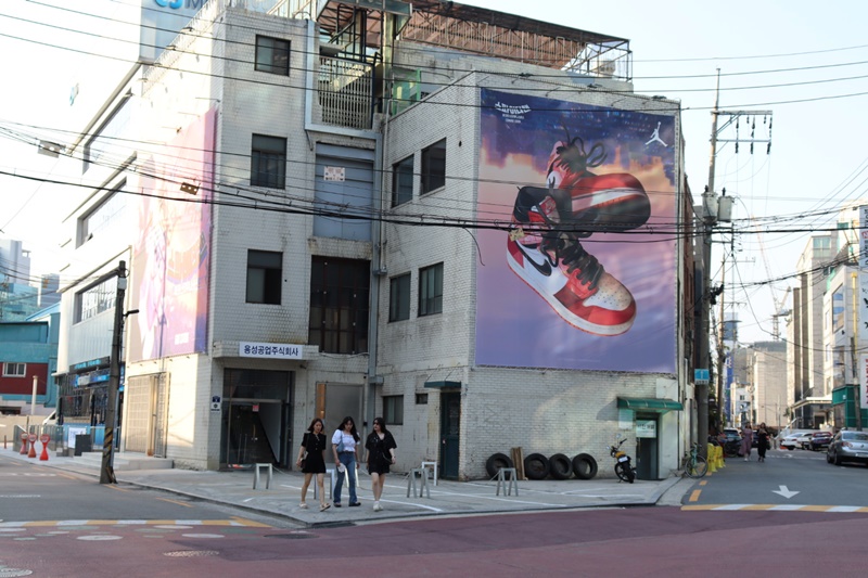 Un cartel promocional de una renombrada marca de zapatos se alza en la fachada de una antigua fábrica en el barrio de Seongsu-dong, en el distrito de Seongdong-gu en Seúl.