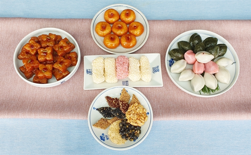Postres emblemáticos que se come durante la festividad de Chuseok. En el sentido de las agujas del reloj desde la izquierda, se muestran mowakgwa, gaseongumegi, songpyeon y gangjeong, en el centro está yugwa. | Lee Kyoung Mi