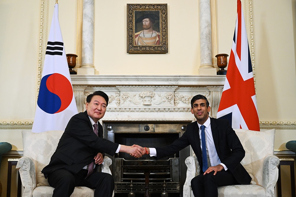 El presidente de Corea del Sur, Yoon Suk Yeol (izquierda), y el primer ministro del Reino Unido, Rishi Sunak, se saludan con un apretón de manos, el 22 de noviembre (hora local), durante su cumbre en la oficina del primer ministro, en Londres. 