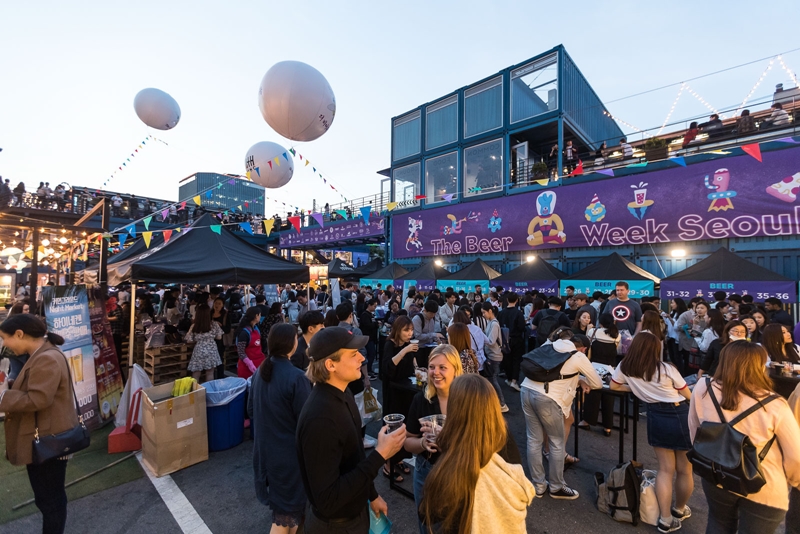 La foto muestra a unos visitantes extranjeros en la Semana de la Cerveza de Seúl, celebrada en junio en Common Ground, la primera tienda pop-up nacional construida con contenedores de transporte, en el distrito de Gwangjin-gu de la capital. | Página oficial de la Organización de Turismo de Corea en Facebook