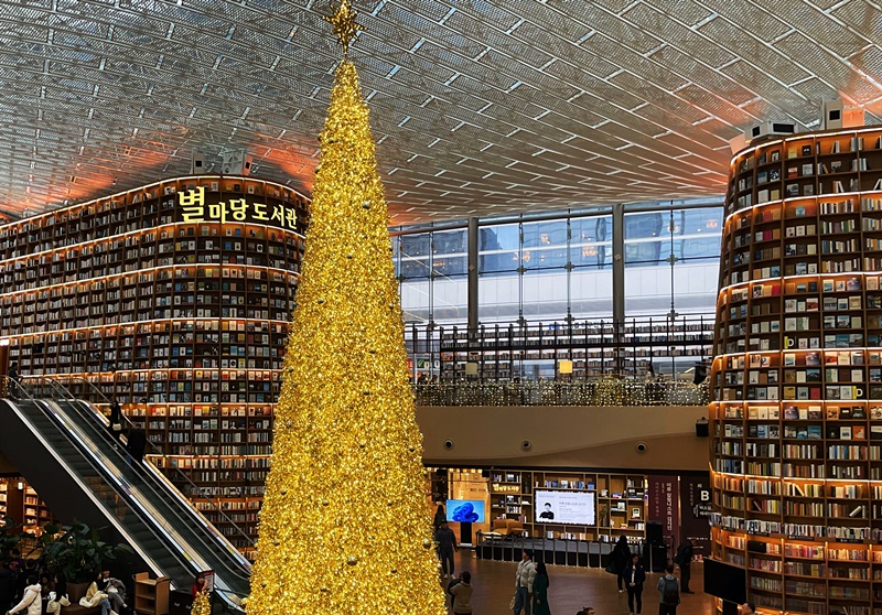 Cada año, un árbol de Navidad dorado de 11 metros de altura da la bienvenida a los visitantes de la biblioteca Starfield, que cuenta con más de 70.000 libros, en el centro de convenciones COEX, en el distrito de Gangnam-gu de Seúl. También se exhiben obras de arte multimedia en una estantería de 13 metros de altura. | Lee Dasom 
