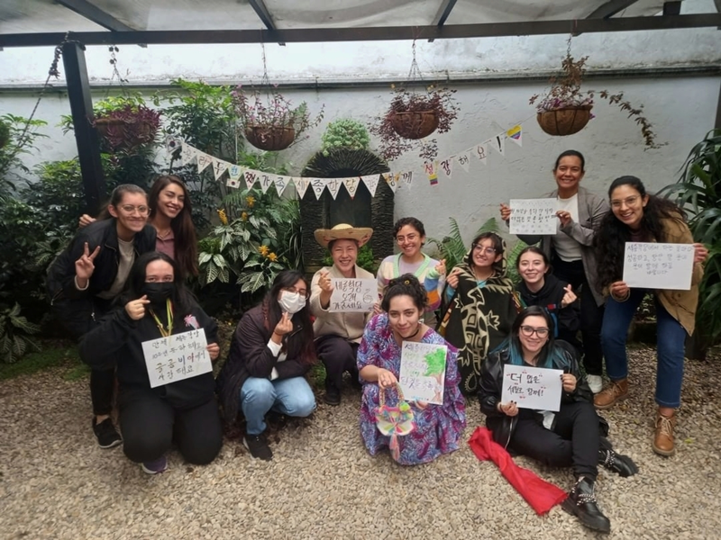 Las estudiantes sonríen y toman fotografías conmemorativas después de escribir sus deseos en coreano, durante una clase de caligrafía que se llevó a cabo en septiembre de 2022, en las instalaciones del Instituto Sejong Bogotá, en Colombia, para conmemorar el 10º aniversario de la inauguración del mismo.