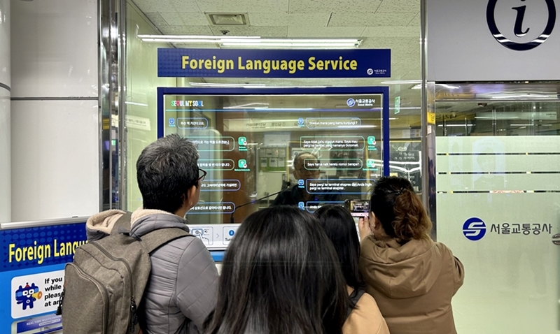 La fotografía muestra a unos turistas extranjeros utilizando el sistema de interpretación simultánea en idiomas extranjeros en la estación de Myeongdong en diciembre del año pasado. | Choi Jin-woo