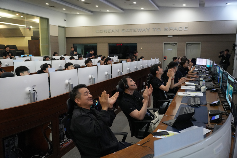 La foto muestra al equipo de control de la estación terrestre en Daejon aplaudiendo tras el exitoso lanzamiento del NEONSAT-1 y el establecimiento de la comunicación bidireccional.