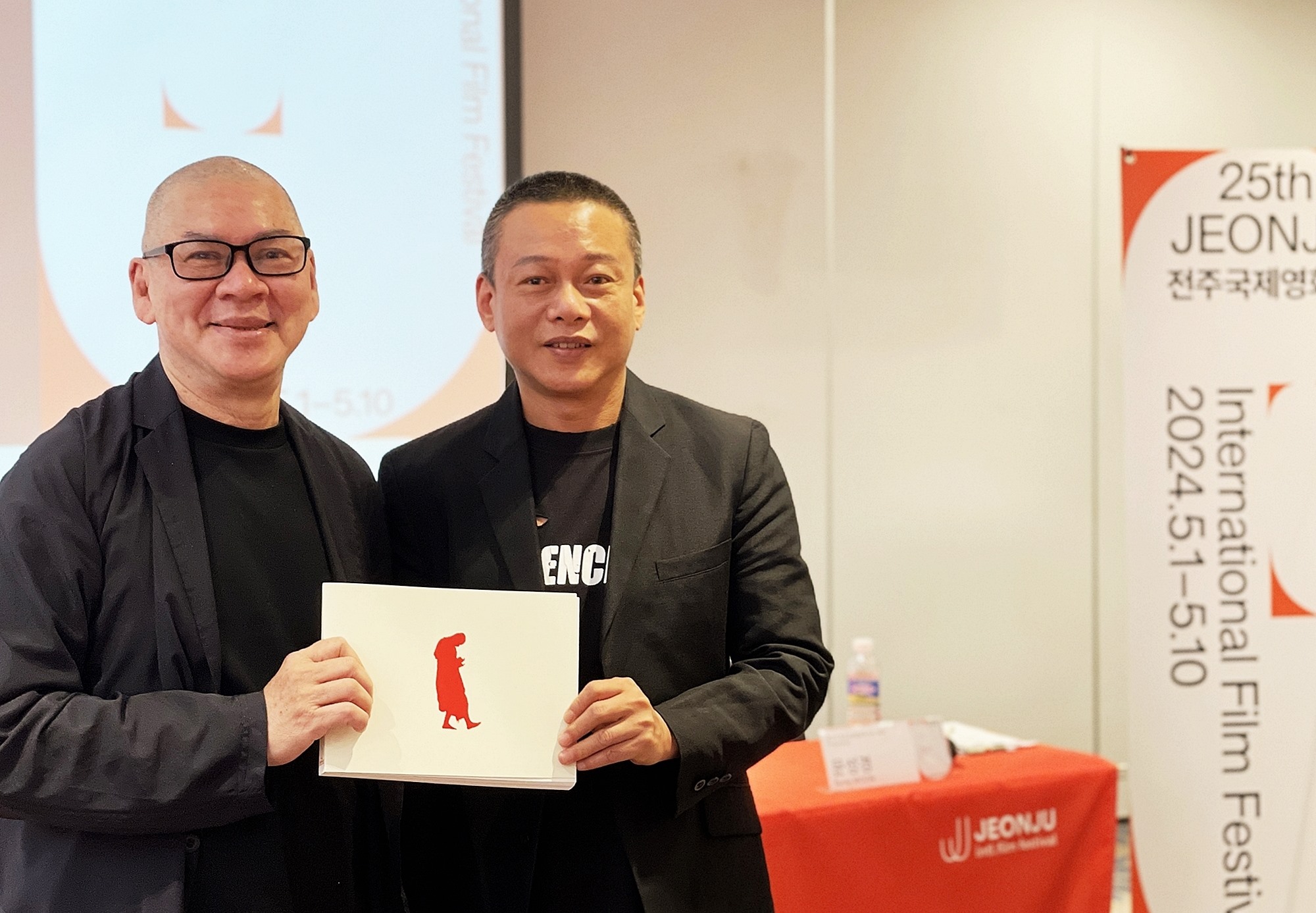 El director Tsai Ming-Liang (izquierda) y el actor taiwanés compatriota Lee Kang-sheng, se toman una fotografía el 3 de mayo, mientras sostienen el programa de la exposición especial del Festival Internacional de Cine de Jeonju de este año, durante una conferencia de prensa en el Best Western Plus Jeonju Hotel, ubicado en el distrito Wansan-gu de dicha ciudad, en la provincia de Jeollabuk-do.