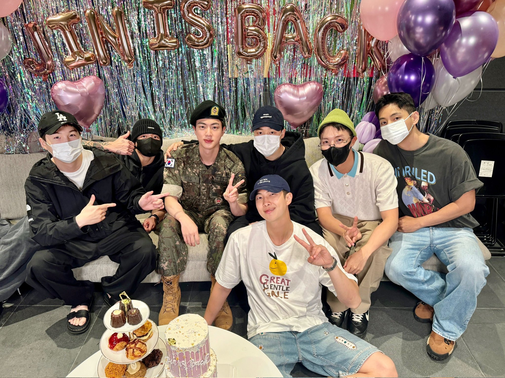 Los siete miembros de BTS posan el 12 de junio en la oficina de Hybe en el distrito de Yongsan-gu, Seúl para celebrar el regreso de Jin (tercero por la izquierda). | Cuenta oficial de BTS en X