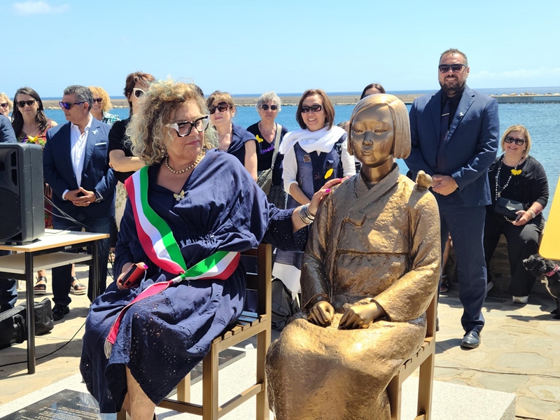 El 22 de junio (hora local), se celebró en Stintino, ciudad de la isla turística italiana de Cerdeña, la ceremonia de inauguración de la primera 'Estatua para la Paz' de Italia. En la imagen, la alcaldesa de Stintino, Rita Vallebella (izda.), toca el hombro de la estatua. | Consejo Coreano para la Justicia y el Recuerdo de las Cuestiones de la Esclavitud Sexual Militar de Japón