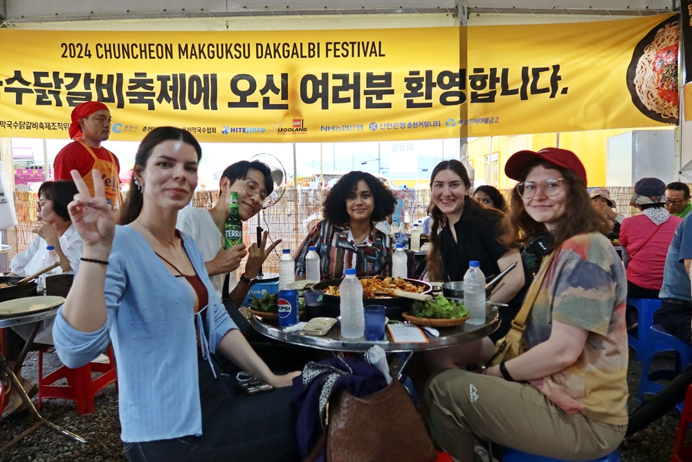  El 22 de junio, unos extranjeros disfrutan del Festival del Makguksu y el Dakgalbi de Chuncheon, comiendo dakgalbi con cerveza.