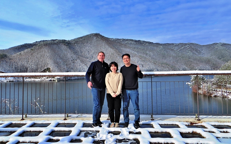 Los autores del libro 'Senderismo por los parques nacionales de Corea' (Hiking the National Parks of Korea): Christian Jorgensen (izquierda), Yoon Hong-geun, director general del Centro Natural del Parque Nacional Sobaeksan (derecha), y Park Hyeon-jeong, una miembro del personal del centro que habla inglés con fluidez, se toman una foto con la montaña Sobaeksan de fondo. Los tres se reunían a menudo en la oficina de gestión del centro para discutir el contenido que se incluiría en Senderismo en los parques nacionales de Corea. | Christian Jorgensen
