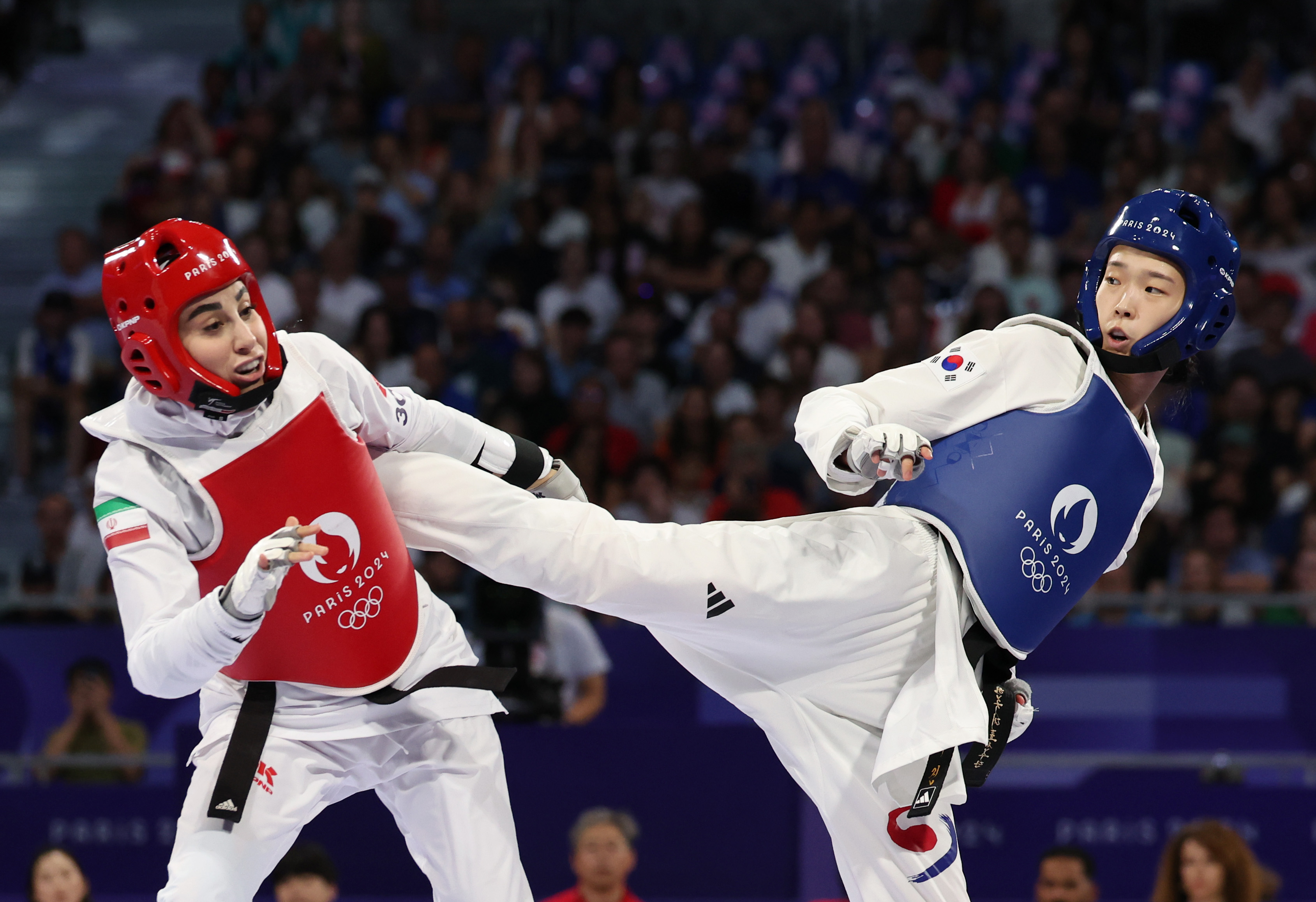 El 8 de agosto (hora local), Kim Yujin (derecha) compite contra la iraní Nahid Kiyanichandehen la final de la categoría de taekwondo femenino de menos de 57 kilogramos en los Juegos Olímpicos de París 2024, en el Grand Palais de la capital francesa.