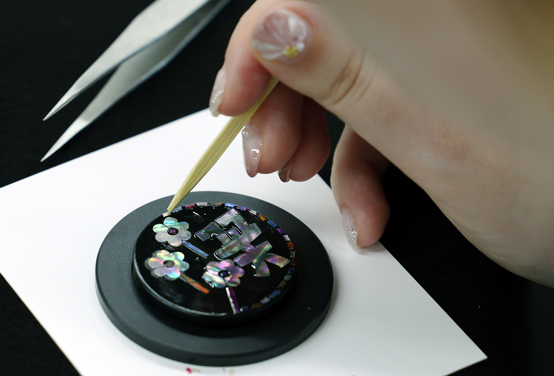 Una participante en el taller de artesanía en nácar en el Seoul Culture Lounge crea un soporte para teléfono el 9 de agosto con las letras en coreano para flor.