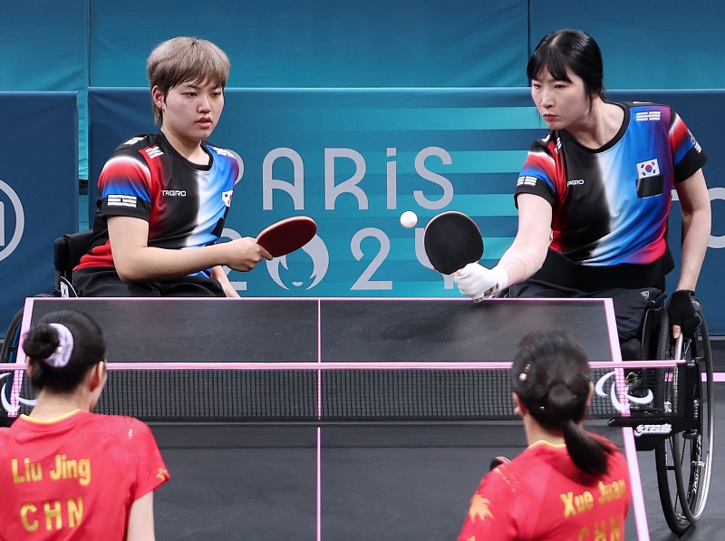 El 30 de agosto (hora local), Seo Su-yeon (derecha) y Yoon Ji-yu juegan contra el equipo chino en la final de dobles femeninos de tenis de mesa, en el estadio Sur de París 4, en la capital francesa. 
