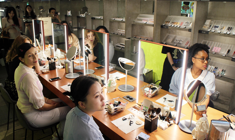 La foto muestra a las turistas extranjeras participando en una clase de maquillaje al estilo coreano.