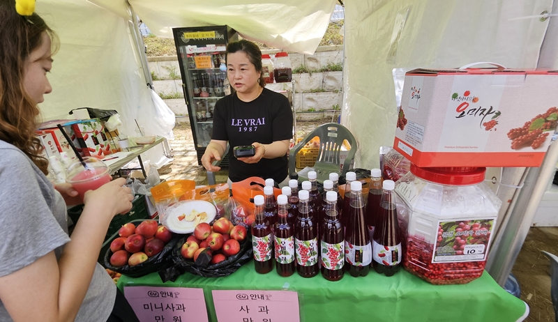 Una visitante compra granizado de omija en un puesto donde se venden productos alimenticios que contienen la baya, como cheong (mermelada) y makgeolli (vino de arroz).