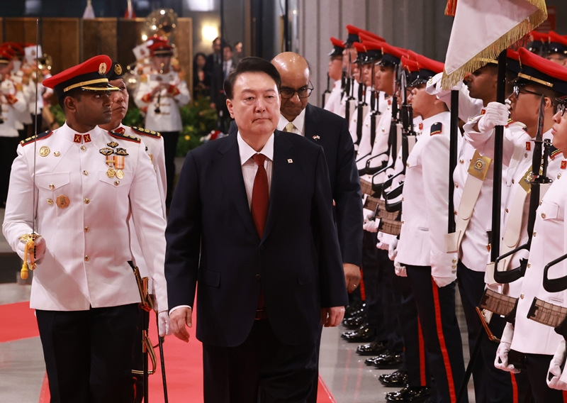 El presidente Yoon Suk Yeol (derecha) inspecciona, el 8 de octubre, una guardia de honor durante su ceremonia oficial de bienvenida junto al presidente de Singapur, Tharman Shanmugaratnam (detrás de Yoon), en el Parlamento de Singapur. | Agencia de Noticias Yonhap 